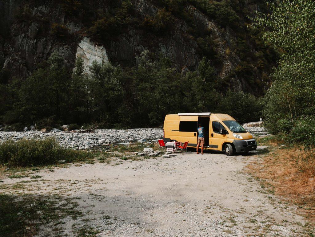 Camping Norditalien, gelber Camper vor Felsen