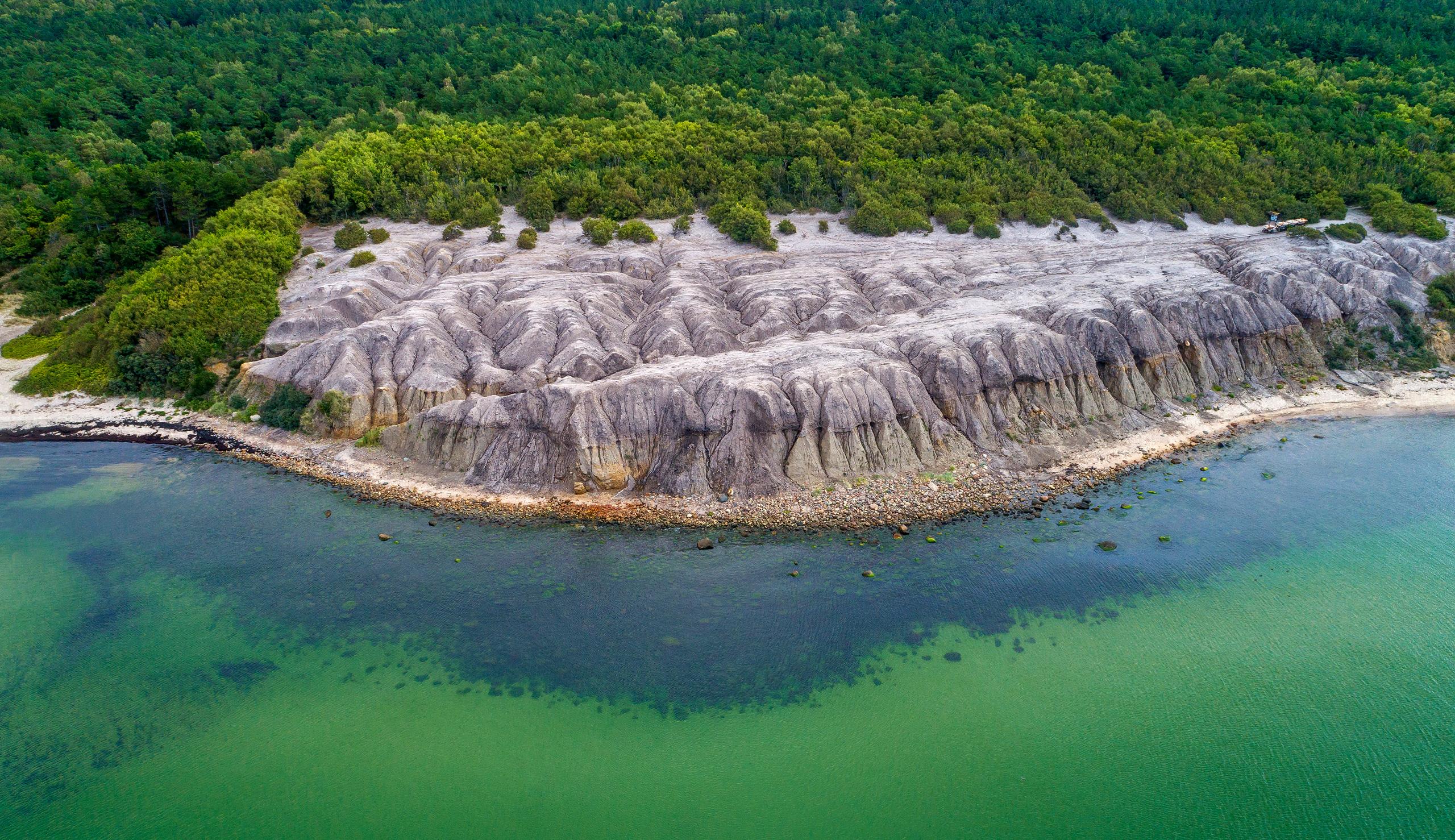 Die bizarre Steinformation der Kultippen bildet einen einzigartigen Kontrast zu den angrenzenden Wäldern und dem türkisblauen Meer. Copyright: Martin Birk / Destination Bornholm
