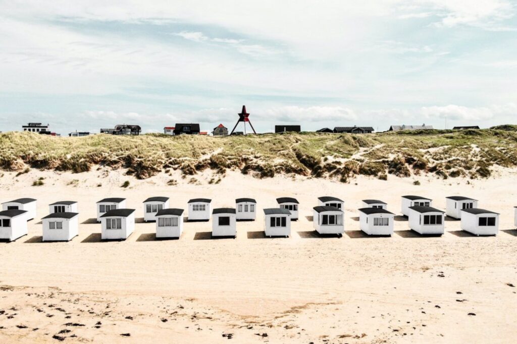 Nesten 500 historiske, hvite badehus ligger på rekke og rad på Løkken Strand og er et flott fotomotiv. Copyright: Daniel Brandt Yesersen / Visit Denmark